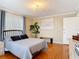 A well-lit bedroom with hardwood floors, neutral decor, a chandelier, and a large window at 20 N Halifax Ave, Daytona Beach, FL 32118