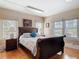 Bright bedroom featuring a sleigh bed, hardwood floors, and multiple windows at 20 N Halifax Ave, Daytona Beach, FL 32118