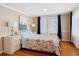 Bright bedroom featuring hardwood floors, neutral wall colors, and white curtains with navy accents at 20 N Halifax Ave, Daytona Beach, FL 32118