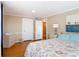 Neutral bedroom featuring hardwood floors, soft lighting, an adjacent bathroom and a dresser with towels at 20 N Halifax Ave, Daytona Beach, FL 32118