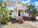 Charming two-story home featuring tropical landscaping, a brick-stepped front porch, and mature trees at 20 N Halifax Ave, Daytona Beach, FL 32118