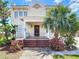 Inviting two-story home with a brick front porch, supported columns, and tropical landscaping at 20 N Halifax Ave, Daytona Beach, FL 32118