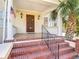 Close-up of the home's entrance, highlighting the brick steps, iron railing, and wood front door at 20 N Halifax Ave, Daytona Beach, FL 32118