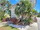 Charming two-story home featuring tropical landscaping, a brick-stepped front porch, and mature trees at 20 N Halifax Ave, Daytona Beach, FL 32118