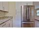 Bright kitchen featuring stainless steel refrigerator, granite countertops, and white cabinets at 2009 Brian Ave, South Daytona, FL 32119