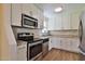 Modern kitchen featuring stainless steel appliances, granite countertops, and white cabinets at 2009 Brian Ave, South Daytona, FL 32119