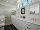 Bathroom with dual sinks, white cabinets, glass shower, and tile flooring at 206 S Riverside Dr, Edgewater, FL 32132