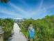 Private beach access path surrounded by lush greenery and stunning natural beauty at 206 S Riverside Dr, Edgewater, FL 32132