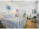 Bedroom featuring a decorative white bed frame, wooden floors, and access to bathroom at 206 S Riverside Dr, Edgewater, FL 32132