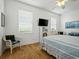 Bright bedroom with wooden floors, white furniture, and a ceiling fan at 206 S Riverside Dr, Edgewater, FL 32132