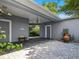 Covered carport with elegant stonework, offering shade and access to a beautifully landscaped area at 206 S Riverside Dr, Edgewater, FL 32132