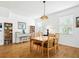 Bright dining room with hardwood floors, a wooden table, and natural light streaming through the windows at 206 S Riverside Dr, Edgewater, FL 32132