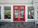 Bright entryway featuring red double doors, decorative windows, and a white spiral staircase at 206 S Riverside Dr, Edgewater, FL 32132