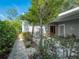 Charming front entrance with a brick walkway, mature landscaping, and a beautiful wood door at 206 S Riverside Dr, Edgewater, FL 32132