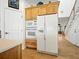 Open kitchen with white appliances, wooden cabinets, and adjacent staircase at 206 S Riverside Dr, Edgewater, FL 32132