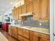 Bright kitchen featuring wooden cabinets and gas range with quartz countertops and stainless backsplash at 206 S Riverside Dr, Edgewater, FL 32132