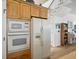 Bright kitchen features white appliances and wooden cabinets with built-in microwave and oven at 206 S Riverside Dr, Edgewater, FL 32132