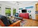 Inviting living room with a large window, cozy seating, TV, and colorful decor at 206 S Riverside Dr, Edgewater, FL 32132