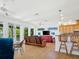 Open-concept living room featuring breakfast bar, ceiling fans, and access to outdoor spaces at 206 S Riverside Dr, Edgewater, FL 32132