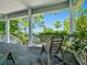 Covered porch provides scenic views of the mature trees, tropical landscaping, and waterfront at 206 S Riverside Dr, Edgewater, FL 32132