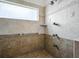 A walk-in shower featuring a built-in bench, window and grab bars at 206 S Riverside Dr, Edgewater, FL 32132