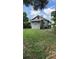 The exterior back of the home shows the lawn and the back of the structure at 215 Alma Ct, New Smyrna Beach, FL 32168