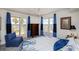 Bright bedroom with balcony access, a blue accent chair, and serene decor for comfortable living at 2300 N Atlantic Ave # 203, Daytona Beach, FL 32118