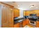 A well-lit kitchen featuring stainless steel appliances, light wood cabinets, and granite countertops at 2300 N Atlantic Ave # 203, Daytona Beach, FL 32118