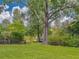 Lush backyard with mature trees and tranquil lake views, offering a serene outdoor escape at 2338 Tuscarora Trl, Maitland, FL 32751