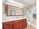 Updated bathroom with rich wood cabinets and a large mirror at 2338 Tuscarora Trl, Maitland, FL 32751