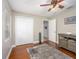 This bedroom features wood floors, a ceiling fan, and a large window at 2338 Tuscarora Trl, Maitland, FL 32751