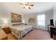 Bright bedroom featuring a queen bed, ceiling fan, and two large windows at 235 Randle Ave, Oak Hill, FL 32759