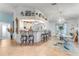 View of kitchen and dining area, showing a bar, white cabinets, tile flooring, and seating for entertaining at 235 Randle Ave, Oak Hill, FL 32759