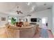 This spacious living room features lots of seating and light, with a TV, decor and a door to another room at 235 Randle Ave, Oak Hill, FL 32759