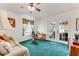 Living room with exterior access, green carpet and beige sofa at 235 Randle Ave, Oak Hill, FL 32759