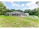 Wide angle view of the backyard with a screen enclosed pool area and white picket fence at 2360 Mooneyham Dr, New Smyrna Beach, FL 32168