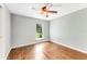 Bright bedroom featuring hardwood floors, a ceiling fan, and a large window offering natural light at 2360 Mooneyham Dr, New Smyrna Beach, FL 32168