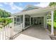 Wide exterior shot showing the home's facade, screened porch, carport, and welcoming white picket fence at 2360 Mooneyham Dr, New Smyrna Beach, FL 32168