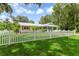 Charming single-story home featuring a white picket fence and lush green lawn at 2360 Mooneyham Dr, New Smyrna Beach, FL 32168