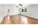 Bright living room featuring hardwood floors, a ceiling fan, and a large window offering natural light at 2360 Mooneyham Dr, New Smyrna Beach, FL 32168