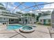 Tranquil backyard oasis featuring a pool with spa, covered patio, and well-maintained landscaping, ideal for relaxation at 2360 Mooneyham Dr, New Smyrna Beach, FL 32168