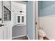 Charming powder room features wainscoting, blue walls, and brick flooring viewed from doorway at 2360 Mooneyham Dr, New Smyrna Beach, FL 32168
