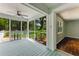 Inviting screened porch with ceiling fan and view of the landscaped backyard and adjacent room with hardwood floors at 2360 Mooneyham Dr, New Smyrna Beach, FL 32168