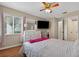 Sunlit bedroom boasting a bright window, a dresser with a TV, and wood flooring at 258 W Sabal Palm Pl # 22, Longwood, FL 32779