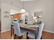 Cozy dining room with seating for four, light fixture, wood flooring, and view into kitchen at 258 W Sabal Palm Pl # 22, Longwood, FL 32779