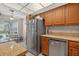 Functional kitchen with a stainless steel dishwasher, wooden cabinets, and a view to the dining area at 258 W Sabal Palm Pl # 22, Longwood, FL 32779