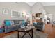Spacious living room featuring a sofa, an armchair, and a view into kitchen and bedroom at 258 W Sabal Palm Pl # 22, Longwood, FL 32779