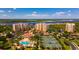 Stunning aerial view of a condo community with pools, tennis courts, and waterfront access at 265 Minorca Beach Way # 902, New Smyrna Beach, FL 32169