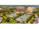 Beautiful aerial view of a condo community featuring a pool, tennis courts, and lush landscaping at 265 Minorca Beach Way # 902, New Smyrna Beach, FL 32169