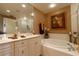 Well-lit bathroom featuring a double sink vanity, soaking tub, and glass enclosed shower at 265 Minorca Beach Way # 902, New Smyrna Beach, FL 32169